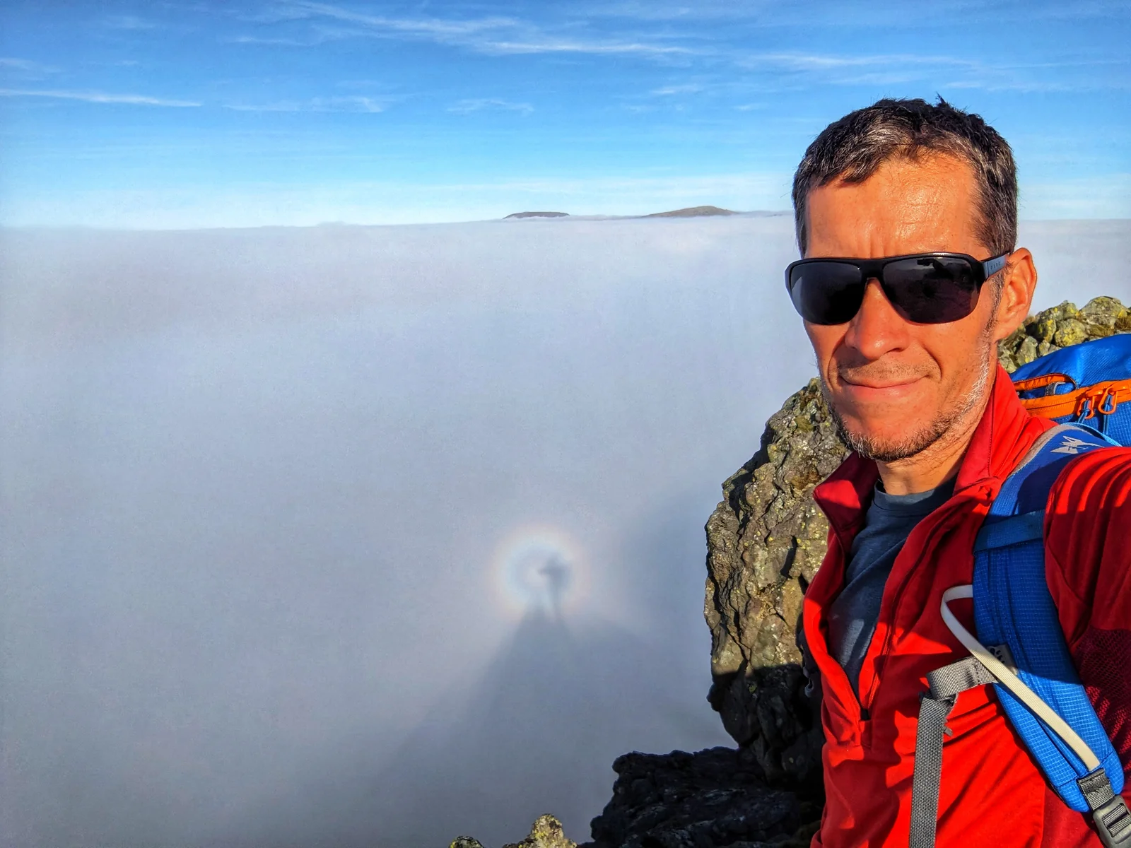 Simon Grogan above a cloud inversion, with a coloured halo around his shadow in the cloud